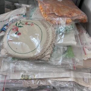 Vintage linen pieces —embroidered doilies, tray cloths, table runners, and crocheted items